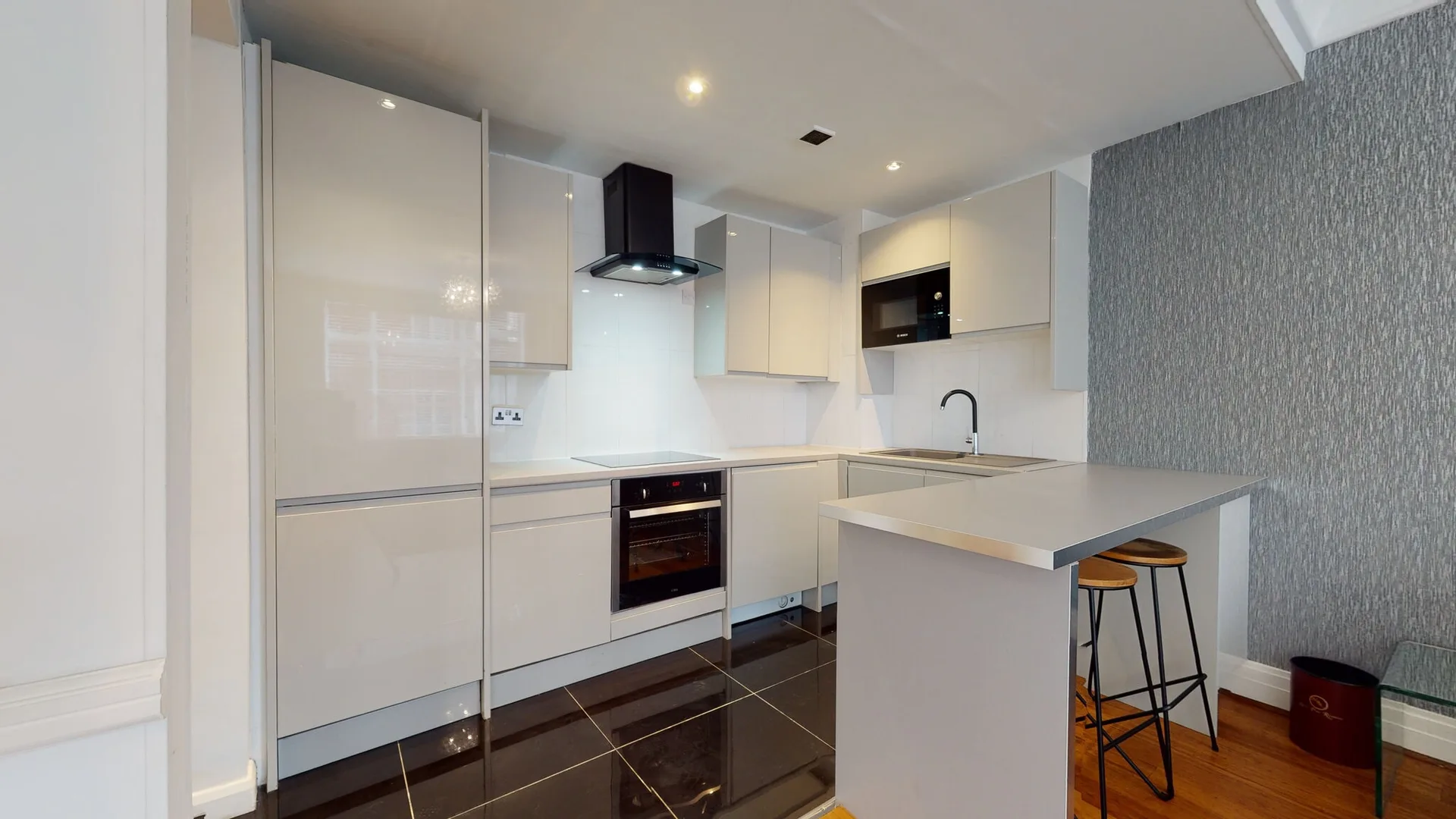 Mayfair apartment white gloss kitchen with a breakfast bar