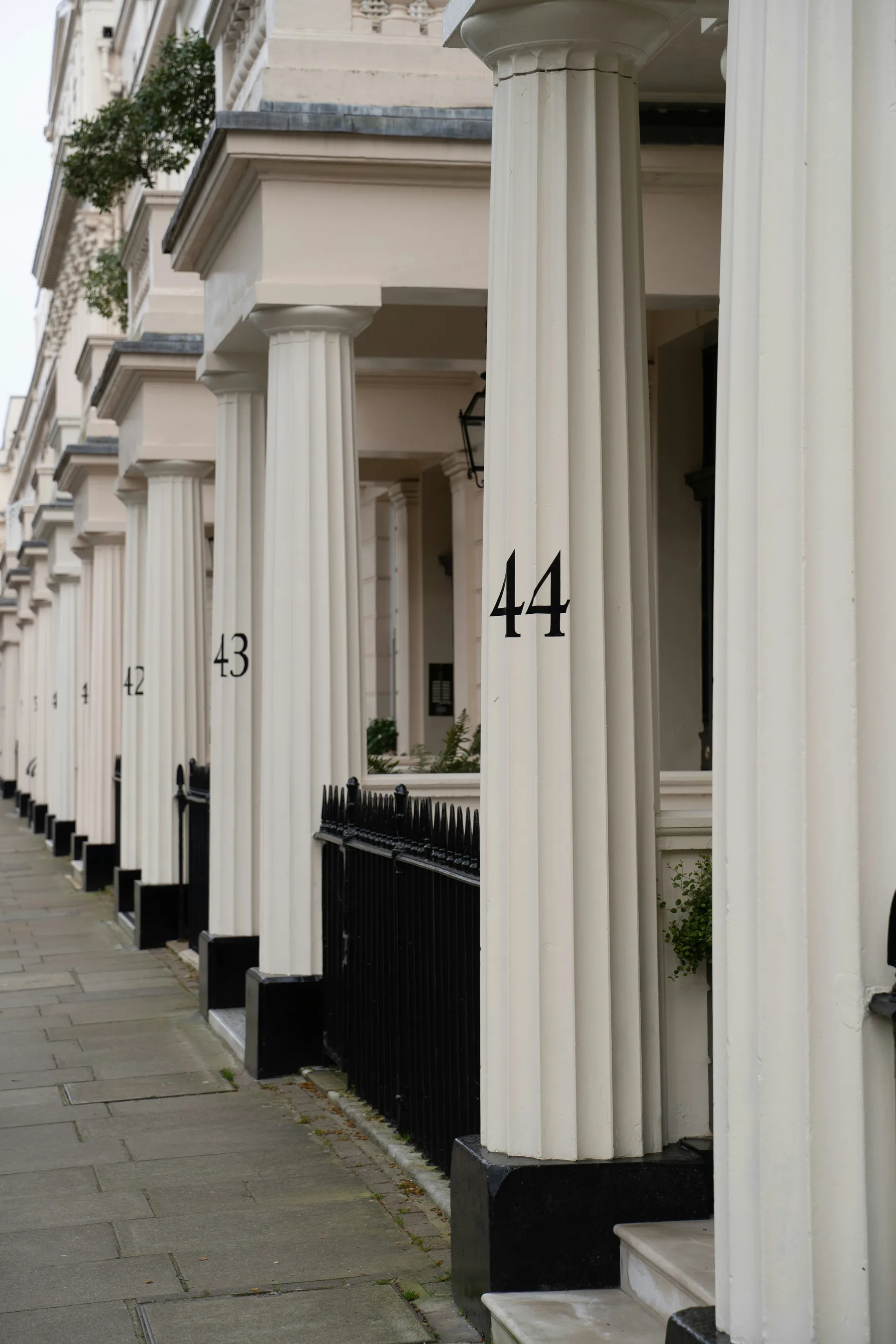 Numbered white columns along a stucco London terrace