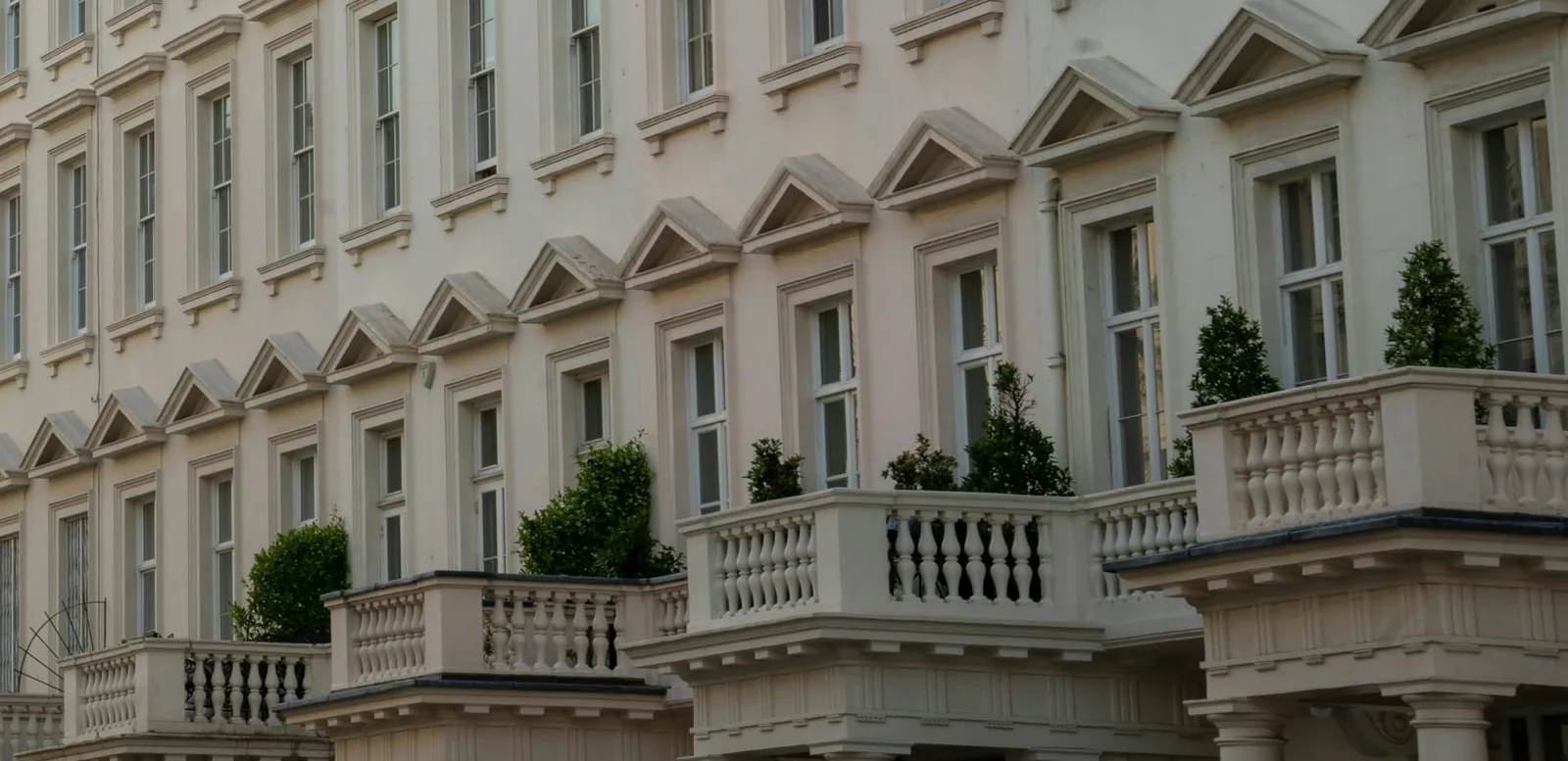 Balustraded balconies and pediments on a cream stucco London terrace