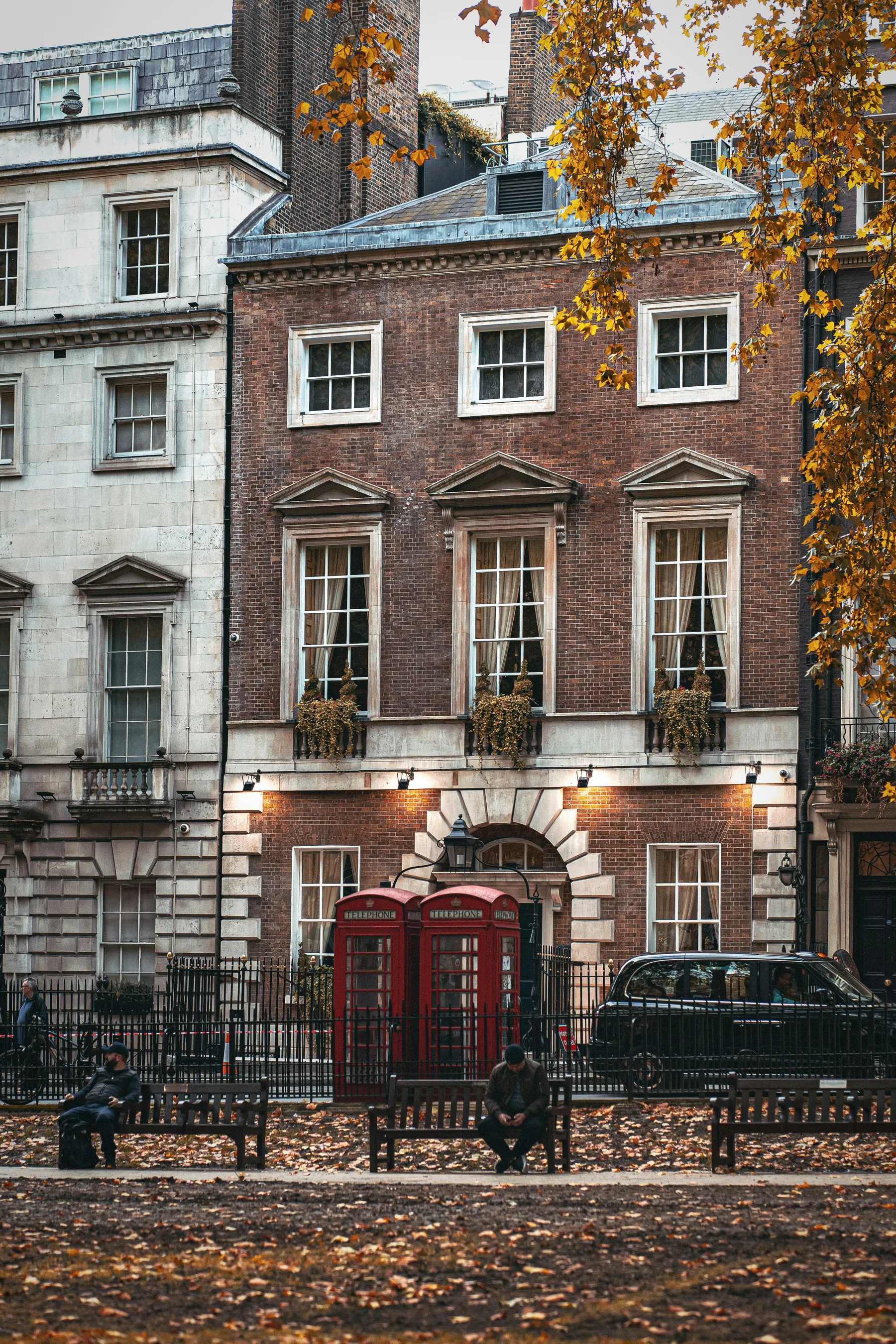Red-brick Georgian townhouse with telephone boxes on a London square